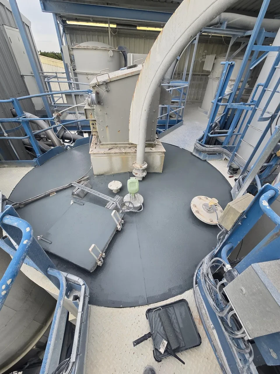Silo walkway after treatment — freshly applied dark anti-slip coating providing grip in wet and powder-contaminated conditions
